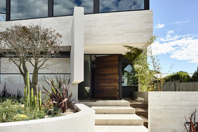 Photo of a contemporary three-storey beige exterior in Melbourne with stone veneer.