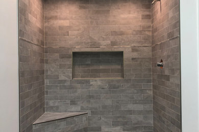 Ceramic tile alcove shower photo in Philadelphia with a hinged shower door