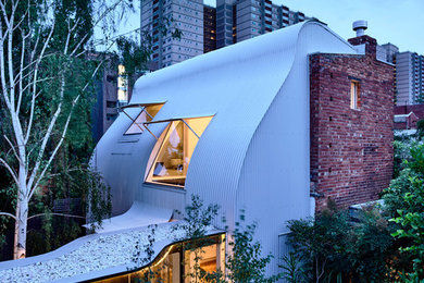 Inspiration for a modern two-storey house exterior in Melbourne with metal siding, a shed roof and a metal roof.