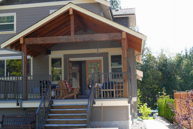Large arts and crafts backyard deck photo in Vancouver with a roof extension