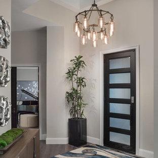 Imagen de distribuidor ecléctico, de tamaño medio, con paredes beige, suelo de baldosas de porcelana, puerta simple, puerta de madera oscura y suelo multicolor