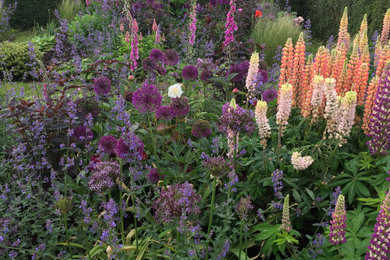 Design ideas for a large farmhouse side formal full sun garden for summer in Kent with a flowerbed and natural stone paving.