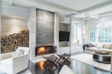 Example of a large trendy open concept dark wood floor and brown floor living room design in Los Angeles with gray walls, a standard fireplace, a wood fireplace surround and a wall-mounted tv