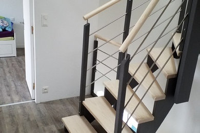 Idées déco pour un escalier courbe contemporain de taille moyenne avec des marches en bois peint et un garde-corps en métal.