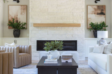 Large transitional open concept light wood floor, vaulted ceiling and wainscoting living room photo in Seattle with gray walls, a standard fireplace and a stacked stone fireplace