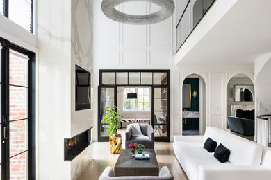 Inspiration for a large transitional open concept light wood floor and beige floor living room remodel in New York with white walls, a ribbon fireplace, a stone fireplace and a media wall