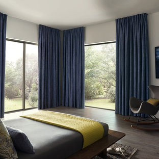 Photo of a large modern master bedroom in Surrey with white walls, dark hardwood flooring and brown floors.
