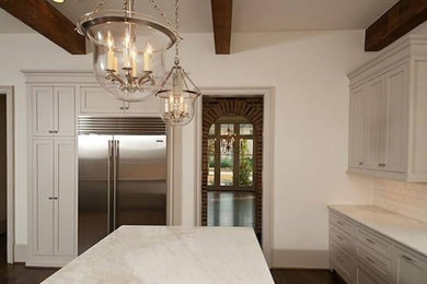 Enclosed kitchen - farmhouse u-shaped dark wood floor and brown floor enclosed kitchen idea in Dallas with shaker cabinets, white cabinets, marble countertops, white backsplash, subway tile backsplash, stainless steel appliances and an island