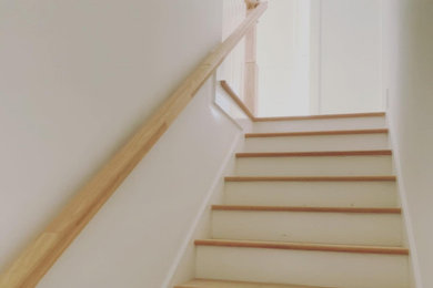 Inspiration for a large transitional l-shaped wood railing staircase remodel in Other