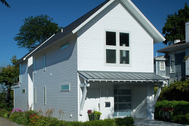 This is an example of a small contemporary two-storey white exterior in Grand Rapids with vinyl siding.