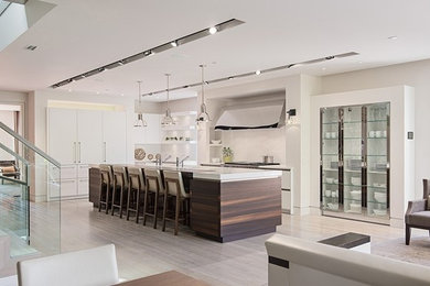 Example of a trendy eat-in kitchen design in Miami with an undermount sink, flat-panel cabinets, white cabinets, granite countertops, white backsplash, stone slab backsplash and stainless steel appliances