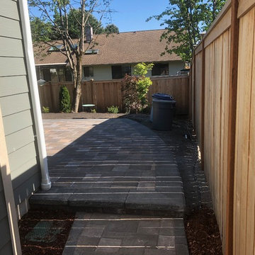 Raised holland patio and walkway with manor stone wall