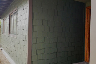 Ejemplo de fachada de casa verde de tamaño medio de una planta con revestimiento de aglomerado de cemento