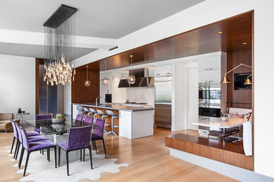 Inspiration for a modern light wood floor open concept kitchen remodel in New York with an undermount sink, raised-panel cabinets, white cabinets, concrete countertops, white backsplash, marble backsplash, stainless steel appliances, an island and gray countertops