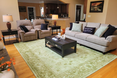 Large elegant open concept medium tone wood floor and beige floor living room photo in Raleigh with beige walls, a standard fireplace and a stacked stone fireplace