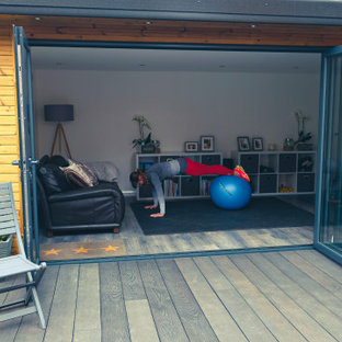 Multifunktionaler, Mittelgroßer Moderner Fitnessraum mit grauer Wandfarbe, hellem Holzboden und grauem Boden in Surrey