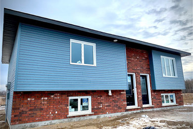 Minimalist blue brick duplex exterior photo in Other with a shingle roof