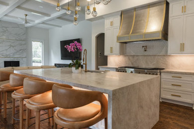 Example of a huge transitional u-shaped medium tone wood floor, brown floor and coffered ceiling open concept kitchen design in Dallas with a single-bowl sink, recessed-panel cabinets, white cabinets, quartzite countertops, beige backsplash, marble backsplash, stainless steel appliances, an island and beige countertops