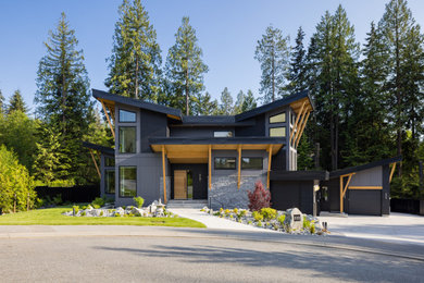 Inspiration for a large contemporary three-story mixed siding house exterior remodel in Vancouver with a shed roof, a metal roof and a black roof