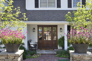 This is an example of a large contemporary front door in Milwaukee with brick floors, a single front door and a medium wood front door.