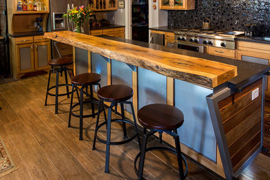 Large minimalist l-shaped light wood floor open concept kitchen photo in Austin with an island, flat-panel cabinets, light wood cabinets, solid surface countertops and stainless steel appliances