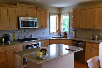 Open concept kitchen - mid-sized u-shaped light wood floor open concept kitchen idea in Minneapolis with an undermount sink, flat-panel cabinets, light wood cabinets, quartz countertops, gray backsplash, stone tile backsplash, stainless steel appliances and an island