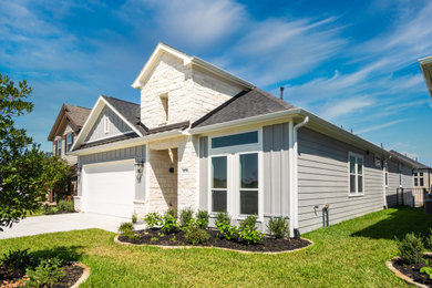 Inspiration for a mid-sized contemporary gray one-story concrete fiberboard house exterior remodel in Houston with a shingle roof and a black roof