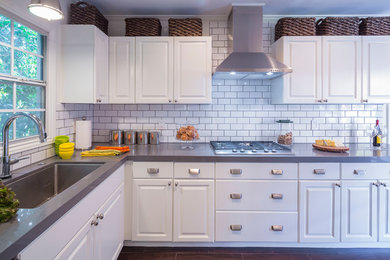Photo of a transitional separate kitchen in Los Angeles with an undermount sink, recessed-panel cabinets, white cabinets, white splashback, subway tile splashback, stainless steel appliances and no island.
