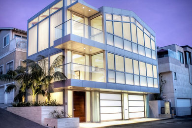 Inspiration for a modern three-storey glass white house exterior in Santa Barbara with a flat roof.