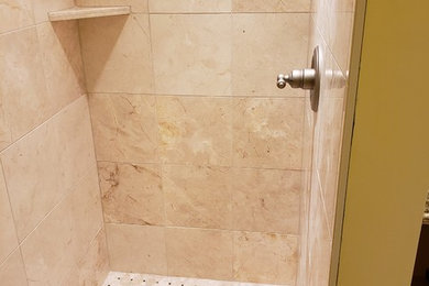Imagen de cuarto de baño clásico de tamaño medio con ducha empotrada, baldosas y/o azulejos de piedra, suelo de travertino, lavabo encastrado, encimera de granito, suelo marrón y ducha con puerta con bisagras