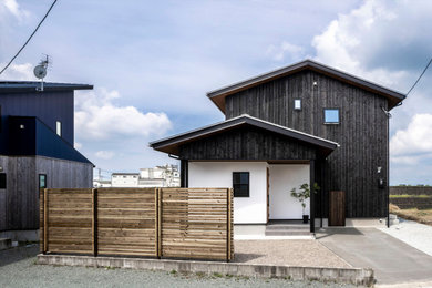 Modelo de fachada de casa negra y gris nórdica de dos plantas con revestimiento de madera, tejado a dos aguas y tejado de metal