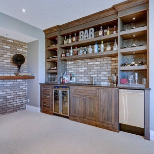 カルガリーのおしゃれなウェットバー (アンダーカウンターシンク、シェーカースタイル扉のキャビネット、中間色木目調キャビネット、御影石カウンター、レンガのキッチンパネル、黒いキッチンカウンター) の写真