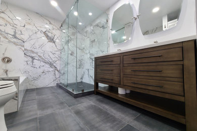 Mid-sized minimalist master white tile and porcelain tile porcelain tile, black floor and double-sink bathroom photo in Seattle with recessed-panel cabinets, medium tone wood cabinets, a two-piece toilet, white walls, an undermount sink, marble countertops, white countertops, a niche and a freestanding vanity