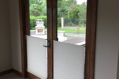 Inspiration for a small timeless medium tone wood floor and brown floor entryway remodel with beige walls and a glass front door