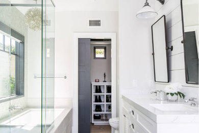 Mid-sized trendy master gray tile and slate tile ceramic tile and multicolored floor corner shower photo in Orange County with white cabinets, an undermount tub, white walls, a hinged shower door, louvered cabinets, an undermount sink and white countertops