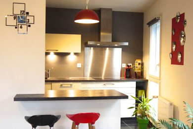 Exemple d'une petite cuisine américaine moderne en U avec un évier encastré, un placard à porte affleurante, des portes de placard blanches, un plan de travail en granite, une crédence métallisée, une crédence en dalle métallique, un sol en carrelage de céramique, aucun îlot, un sol noir et plan de travail noir.