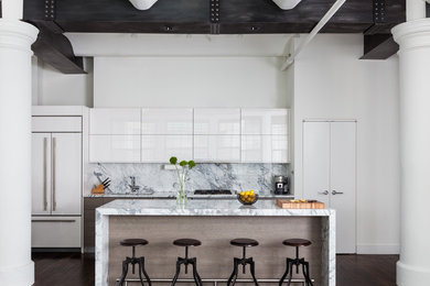 Small urban galley dark wood floor and brown floor open concept kitchen photo in New York with flat-panel cabinets, white cabinets, marble countertops, white backsplash, marble backsplash, white appliances, an island, an undermount sink and gray countertops