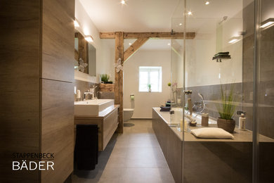 Mittelgroßes Uriges Badezimmer mit flächenbündigen Schrankfronten, Wandtoilette mit Spülkasten, Keramikboden, Aufsatzwaschbecken und grauem Boden in Hamburg