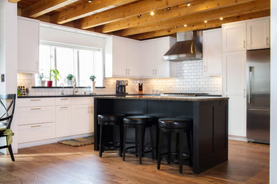 Inspiration for a mid-sized transitional l-shaped medium tone wood floor eat-in kitchen remodel in Other with an undermount sink, shaker cabinets, white cabinets, granite countertops, white backsplash, subway tile backsplash, stainless steel appliances and an island