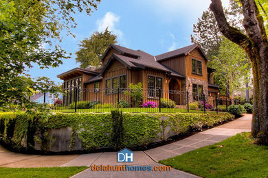 Large traditional brown two-story wood gable roof idea in Portland