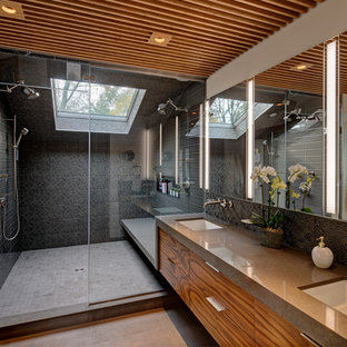 Trendy black tile gray floor alcove shower photo in Chicago with flat-panel cabinets, medium tone wood cabinets, white walls, an undermount sink, a hinged shower door and gray countertops