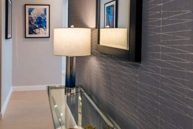 Photo of a small contemporary foyer in New York with grey walls, light hardwood flooring, beige floors and wallpapered walls.