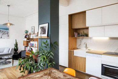 Idées déco pour une petite cuisine ouverte linéaire, bicolore et blanche et bois moderne avec un placard à porte affleurante, des portes de placard blanches, un plan de travail en bois, une crédence blanche, une crédence en céramique, parquet foncé et un plan de travail beige.