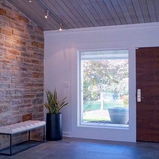 Idée de décoration pour un hall d'entrée design de taille moyenne avec un mur blanc, un sol en ardoise, une porte simple, une porte en bois foncé et un sol gris.