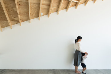 Cette image montre une petite salle de séjour vintage ouverte avec un mur blanc, sol en béton ciré, aucun téléviseur, un sol gris, poutres apparentes et du papier peint.