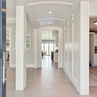 Inspiration för stora klassiska hallar, med vita väggar, ljust trägolv och brunt golv