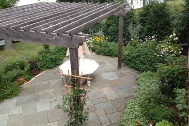 Inspiration for a mid-sized traditional full sun backyard stone landscaping in Minneapolis.