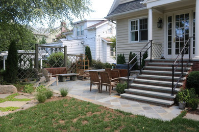 Example of a mid-sized classic backyard stone patio design in DC Metro