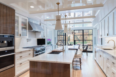 Example of a large transitional u-shaped light wood floor and beige floor eat-in kitchen design in New York with an undermount sink, recessed-panel cabinets, white cabinets, marble countertops, white backsplash, marble backsplash, stainless steel appliances and an island