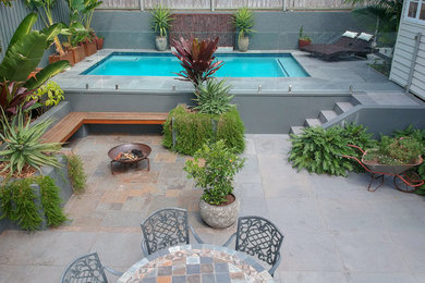 Large contemporary backyard patio in Other with a fire feature and natural stone pavers.